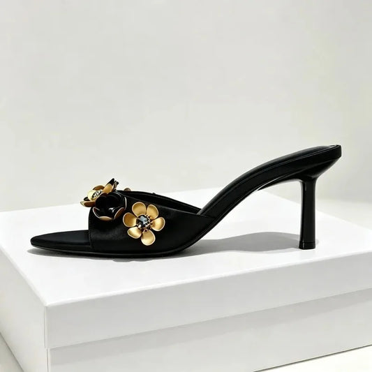 Black heeled mule with metal flower and crystal embellishments