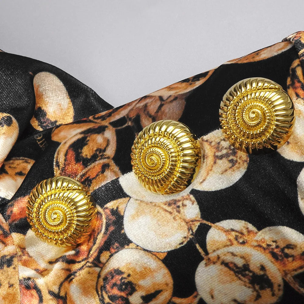 Gold spiral earrings on a patterned fabric background