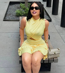 Woman in a yellow dress sitting on a bench outdoors