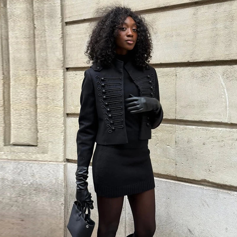 Woman wearing a black outfit with a textured wall background
