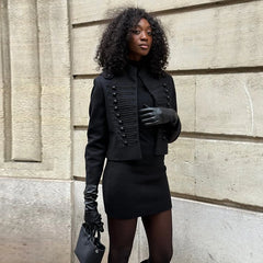 Woman wearing a black outfit with a textured wall background