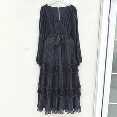 Black ruffled dress hanging on a white door