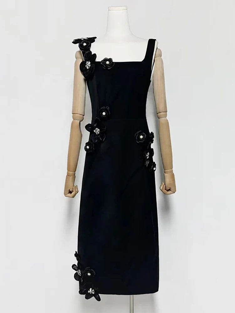 Black dress with floral embellishments on a mannequin against a white background