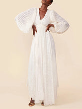 Woman wearing a white lace dress against a beige background