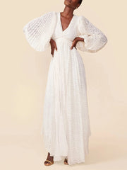 Woman wearing a white lace dress against a beige background