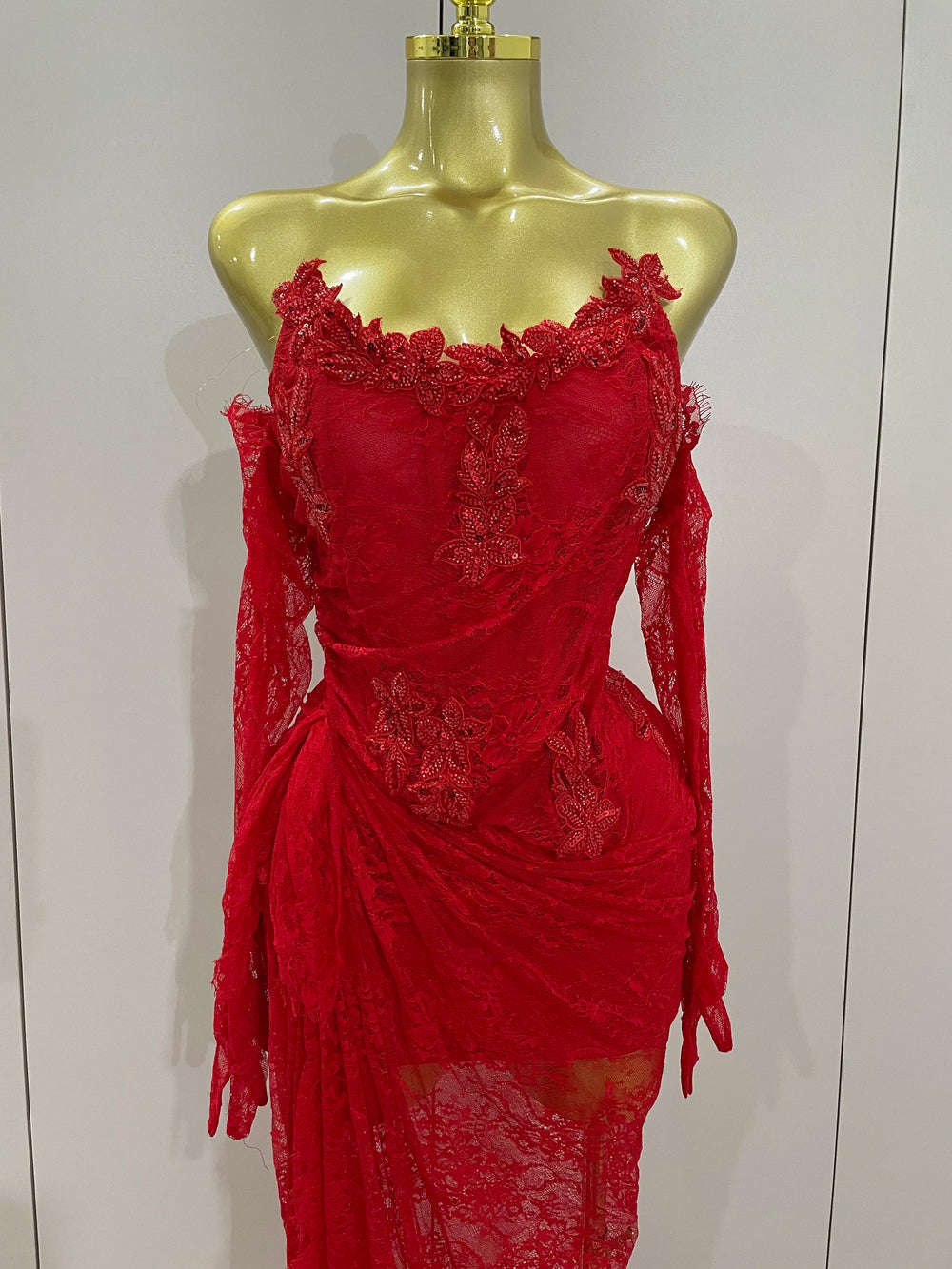 Red lace dress on a mannequin against a white background