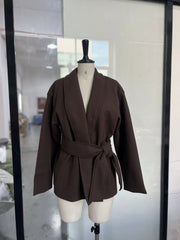 Brown blazer on a mannequin in a room with a mirror.