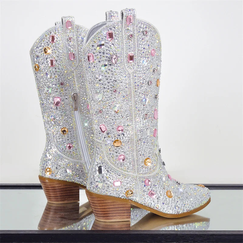 Sparkly cowboy boots with rhinestones on a reflective surface.