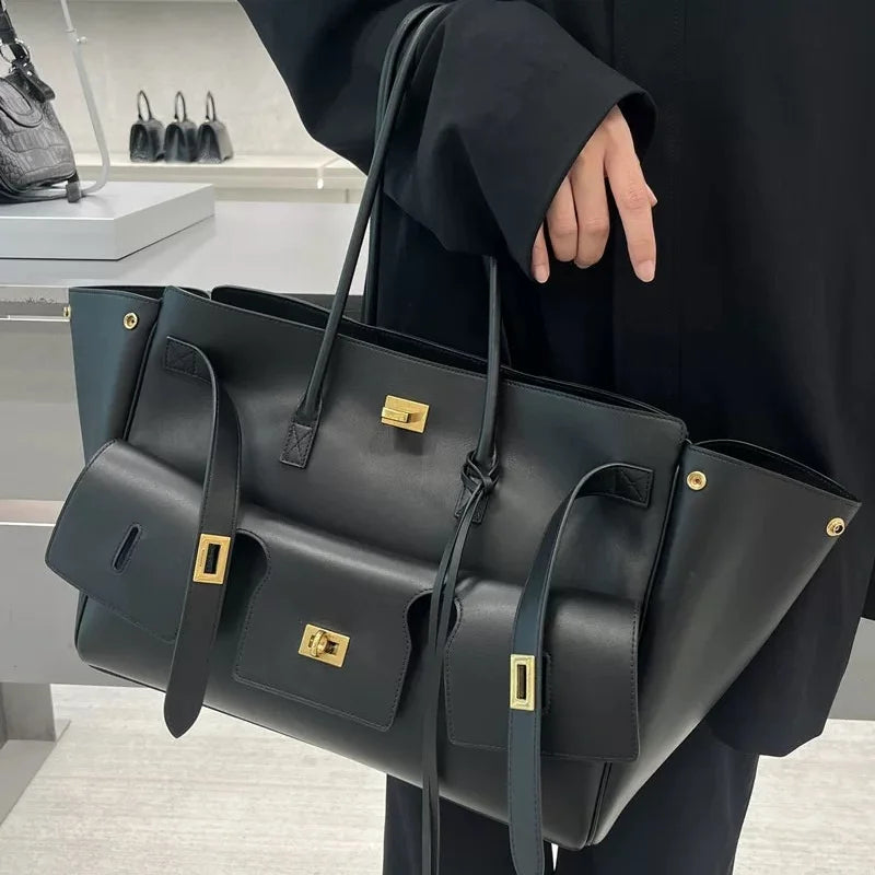 structured black tote bag with gold buckle hardware