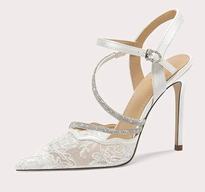 White high-heeled sandal with lace details on a white background