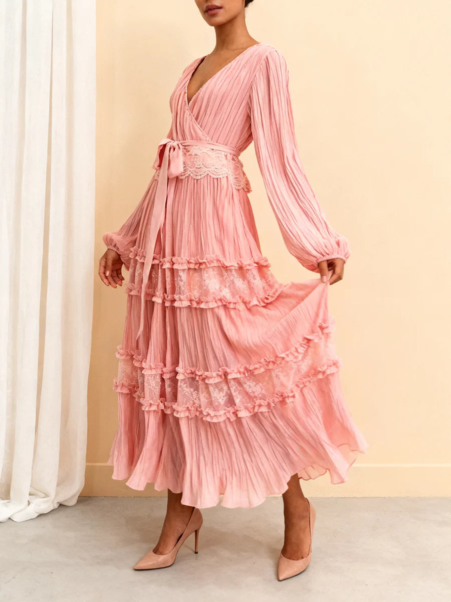 Woman wearing a pink dress with ruffled layers against a beige background