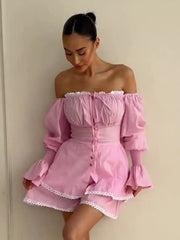 Woman wearing a pink off-shoulder dress with ruffled sleeves and hem.