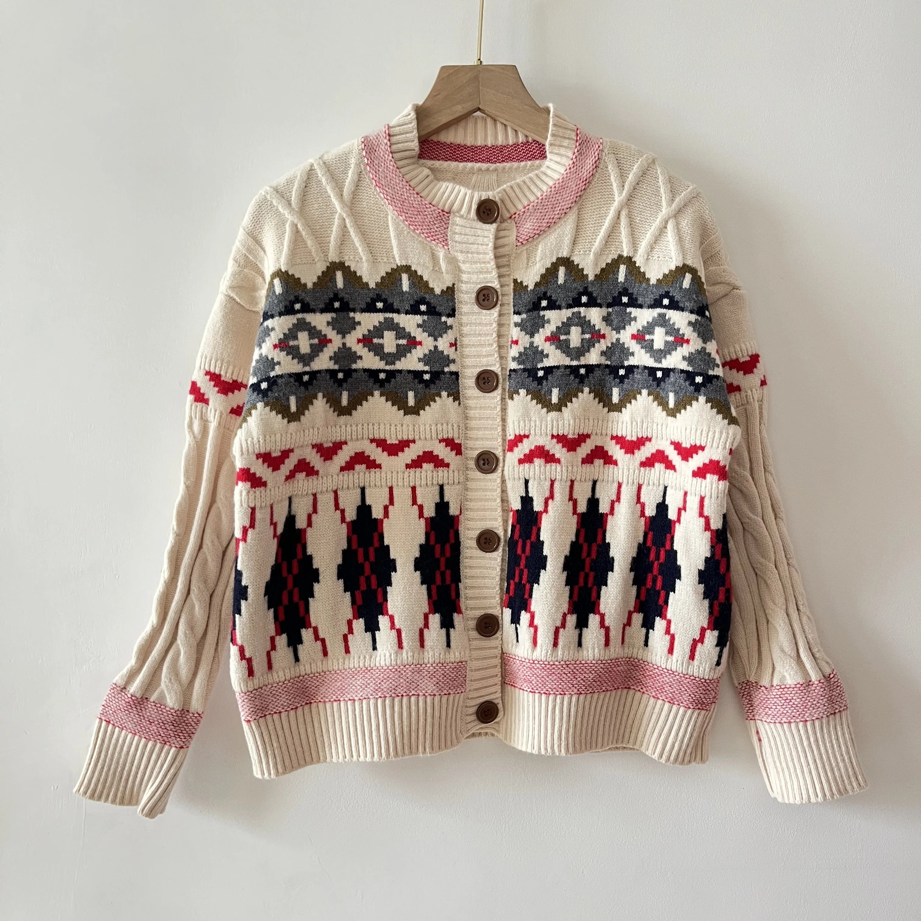 Beige cardigan with a patterned design on a hanger