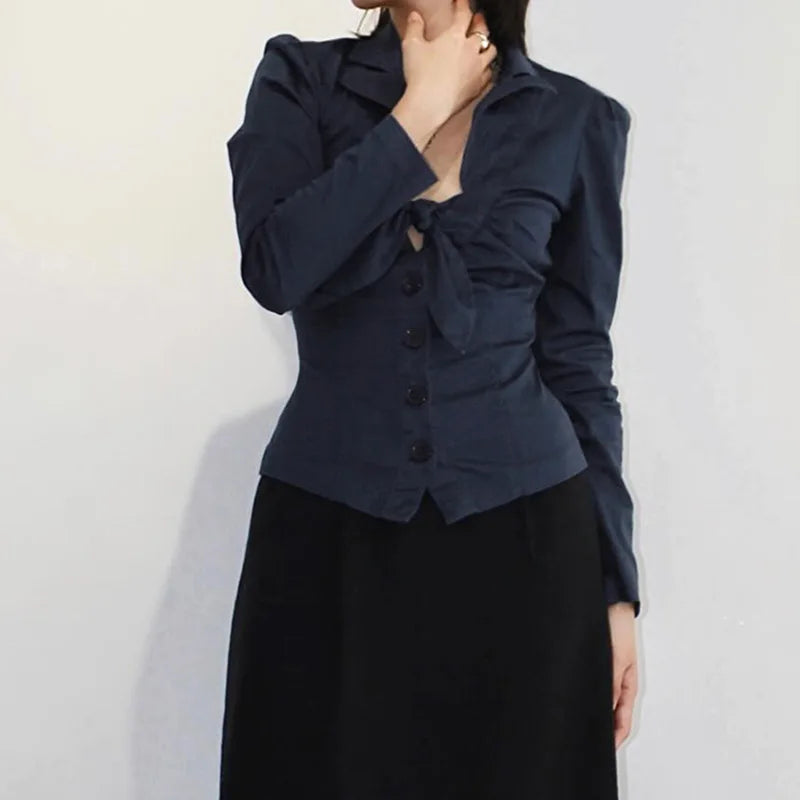 Person wearing a dark blue top over a black top against a light background