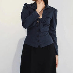 Person wearing a dark blue top over a black top against a light background
