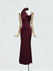 Wine red evening gown on a mannequin against a white background