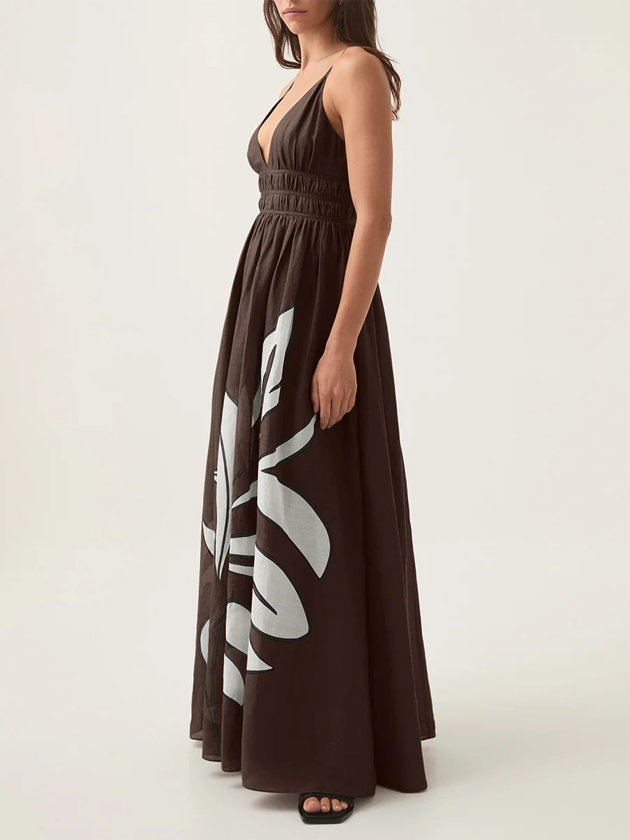 Side profile of a person wearing a brown floral print V-neck shirred empire waist maxi dress