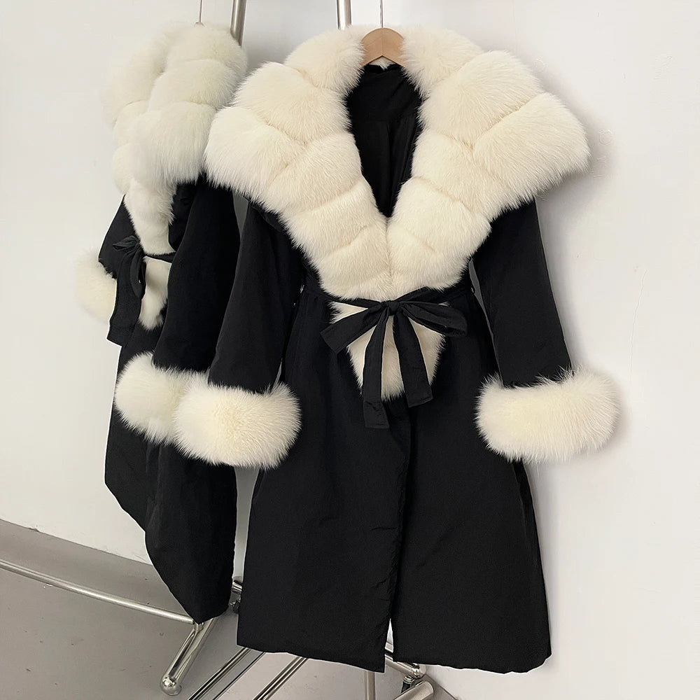 Black coat with white fur trim on a hanger against a white background