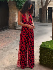 Woman wearing a red floral deep v halter dress outdoors