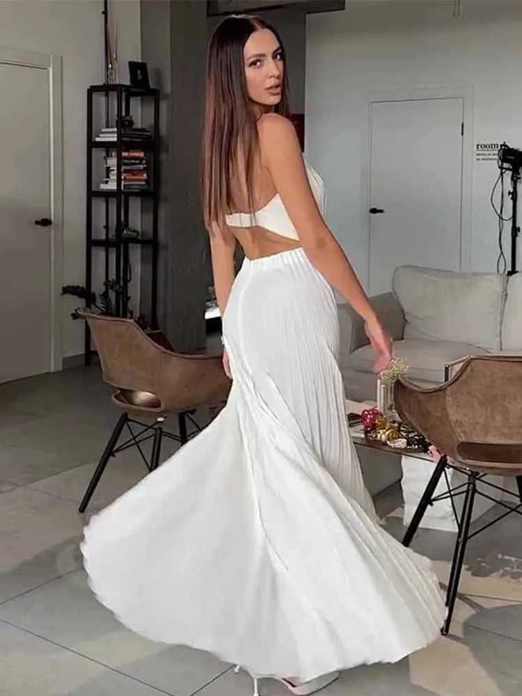 Woman in a white dress standing in a modern living room.