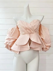 Pink ruffled top on a mannequin against a white background