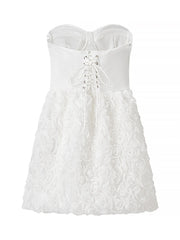 White strapless dress with floral lace details on a white background