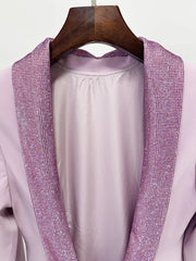Lavender outfit with textured trim on a wooden hanger against a white background