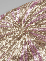 Close-up of a sequined fabric with a starburst pattern in gold, silver, and purple.