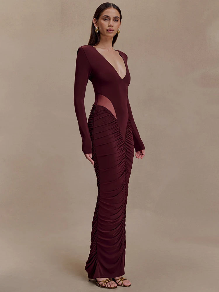 Woman wearing a burgundy evening gown with cut-out design on a beige background