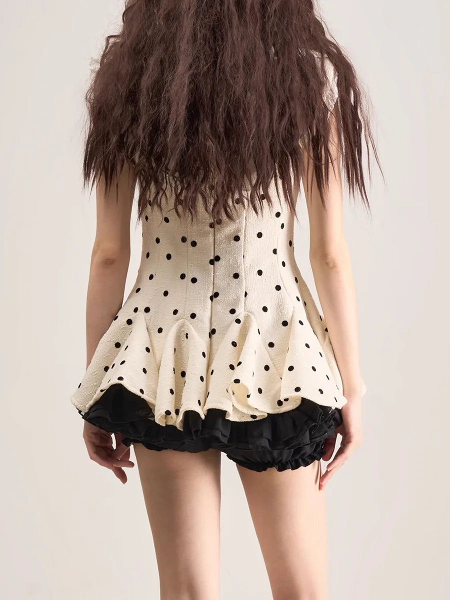 Person wearing a polka dot dress with a plain background