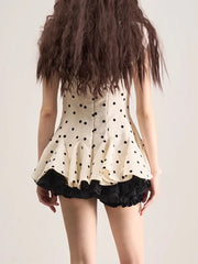 Person wearing a polka dot dress with a plain background