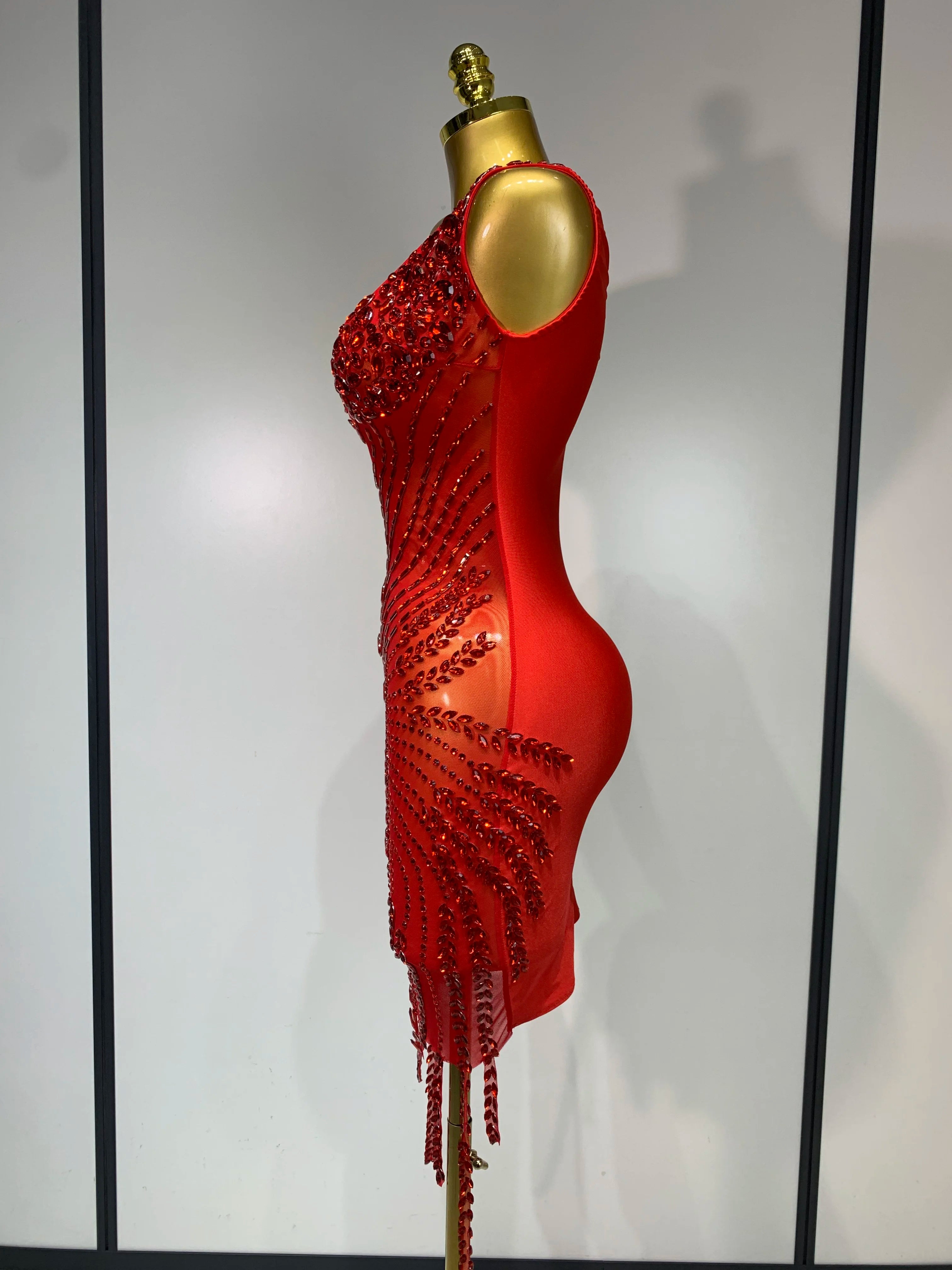 Red beaded dress on a mannequin against a plain background