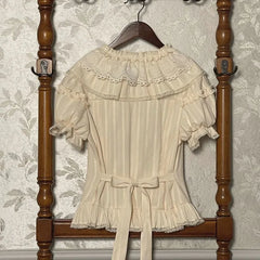 Back view of cream lace collar blouse with bow detail and short puff sleeves