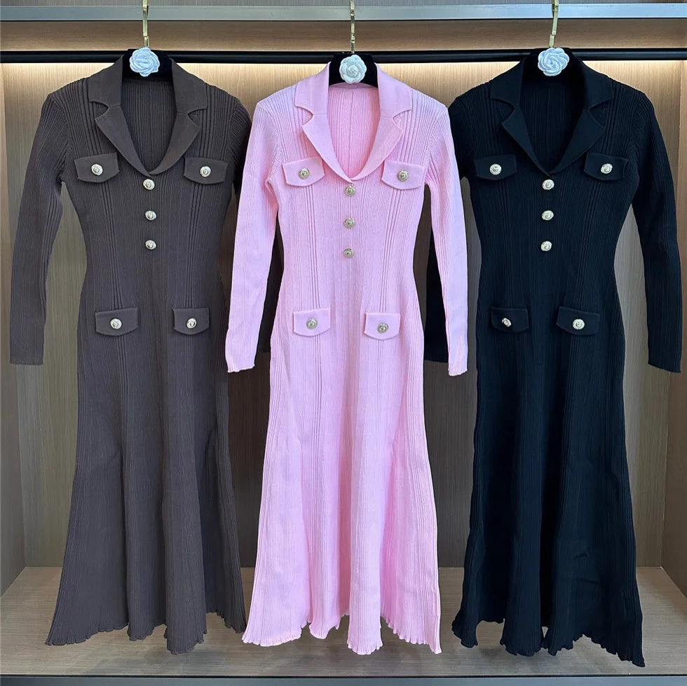 Three long coats in gray, pink, and black hanging on a rack.