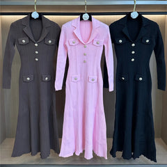Three long coats in gray, pink, and black hanging on a rack.