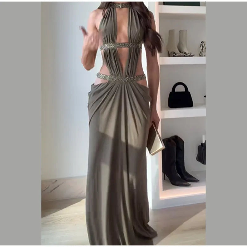 Woman wearing a long, elegant dress with a shelf of shoes and bags in the background.