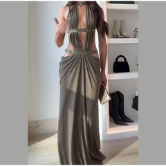 Woman wearing a long, elegant dress with a shelf of shoes and bags in the background.