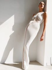 Woman wearing a white dress standing against a light background