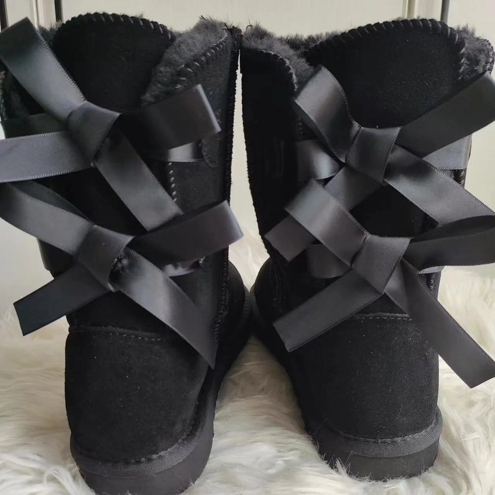 Back view of black plush snow boots with criss-cross ribbon bows