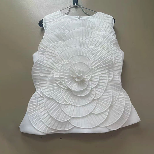 White top with a floral design on a hanger against a beige background