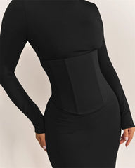 Black long-sleeve dress with a fitted waist on a beige background