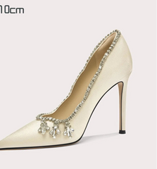 High-heeled shoe with decorative elements on a light gray background