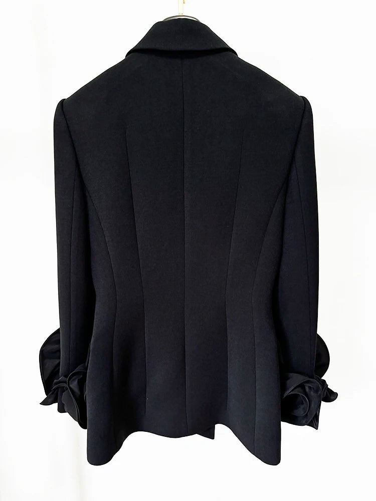 Back view of a sculpted double-breasted black blazer with floral cuff details.