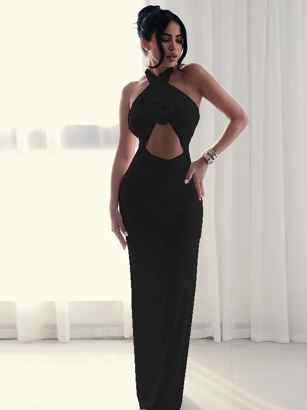 Woman wearing a black evening gown with cut-out design in a minimalistic setting.