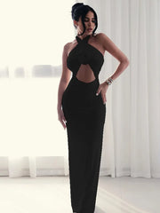 Woman wearing a black evening gown with cut-out design in a minimalistic setting.