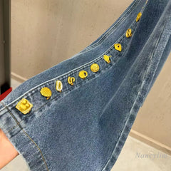 Close-up of denim patchwork button detail on pants