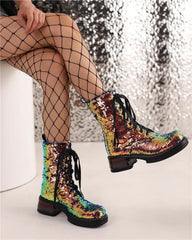 Multicolored sequin boots worn with fishnet stockings against a reflective silver background