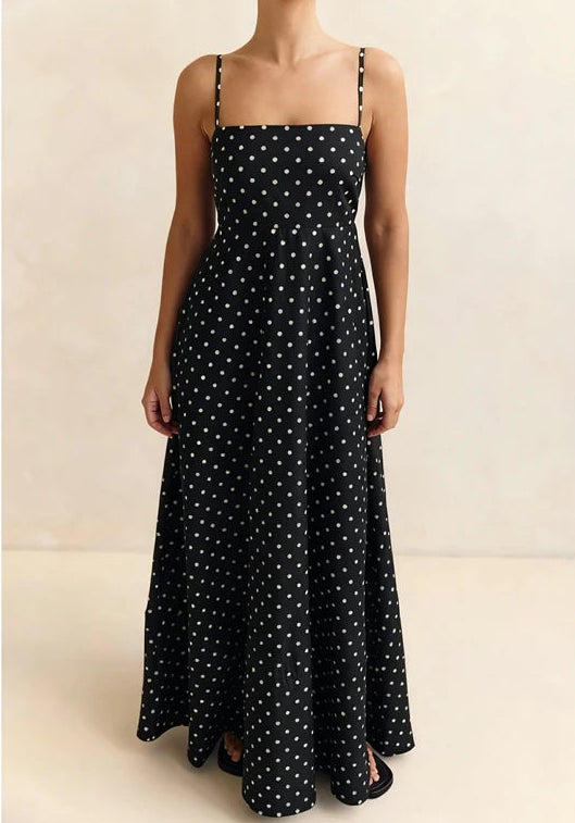 Black polka dot dress on a neutral background