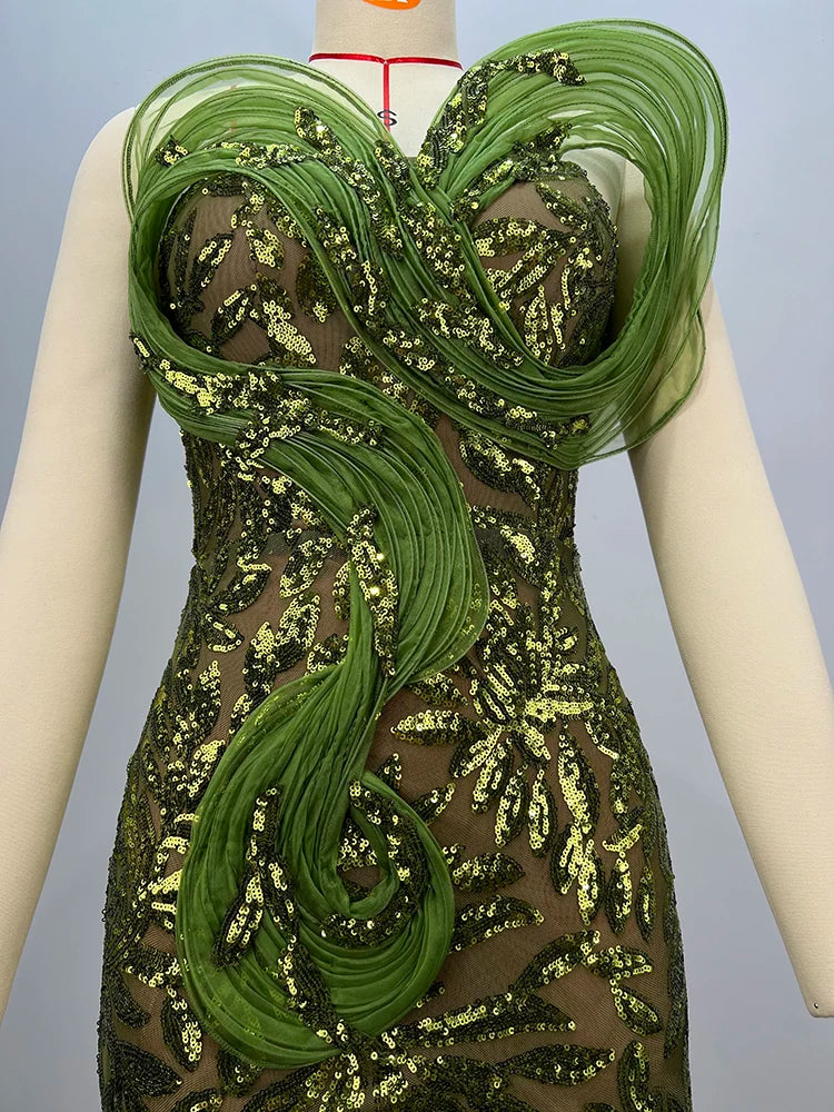 Green and gold dress on a mannequin against a gray background