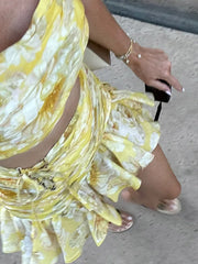 Person wearing a yellow floral dress with a blurred background